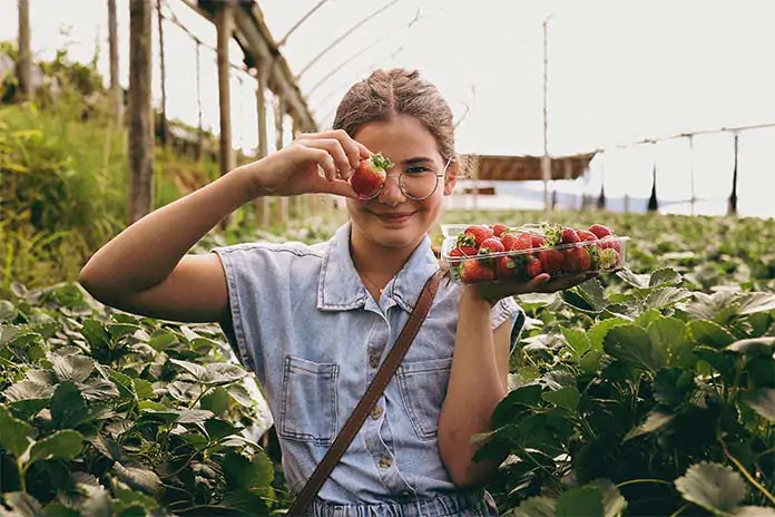 Happy Girl Holding Strawberries